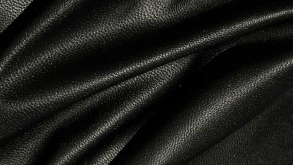 Close-up of black leather texture with soft folds.